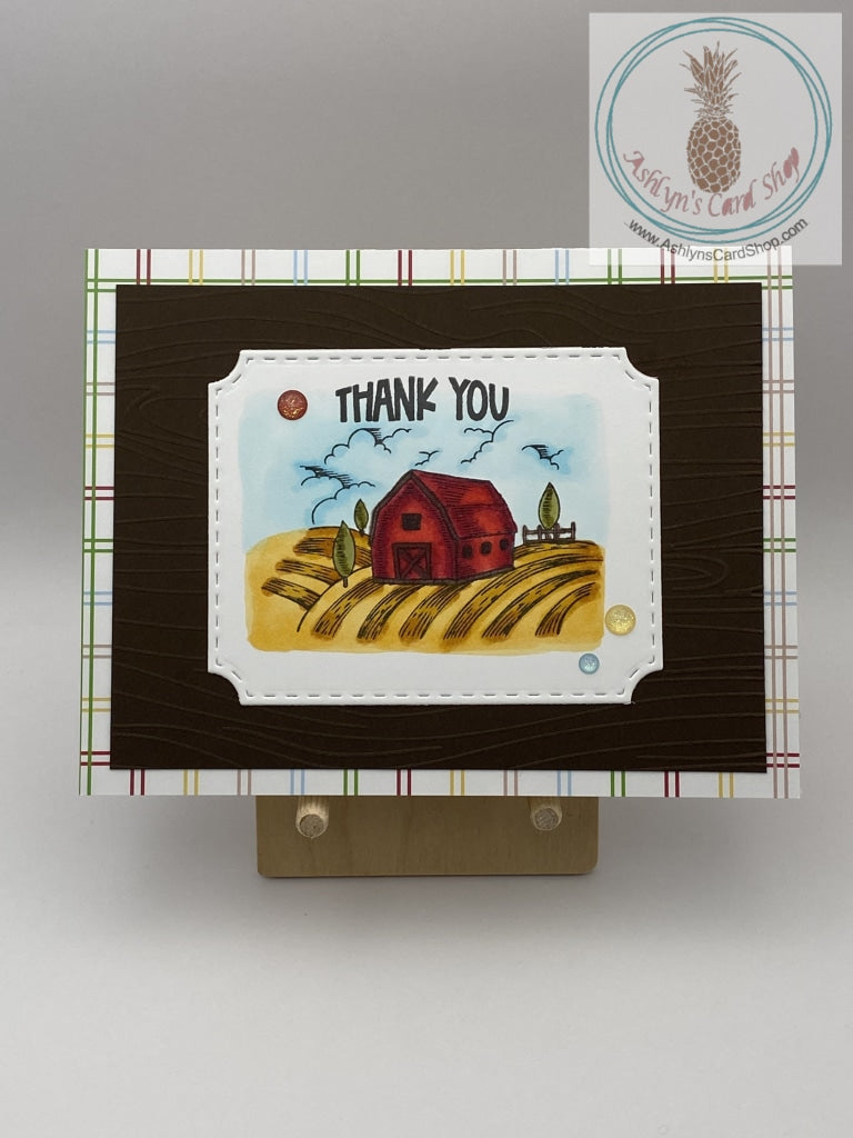 A thank you card with a farm theme. Hand coloured barn scene on brown cardstock and an additional layer of patterned paper (criss cross). A2 size card 4.25 x 5.5". Coordinating envelope included.