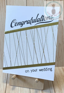 High quality handmade wedding cards featuring simple gold and white designs with  sentiments stamped in black. Decorative tape and foil tape in gold mounted on a white card base.  Sentiments read "Congratulations on your wedding". A2 card size: 4.25 x 5.5".  Coordinating envelope included. Double stripe version.