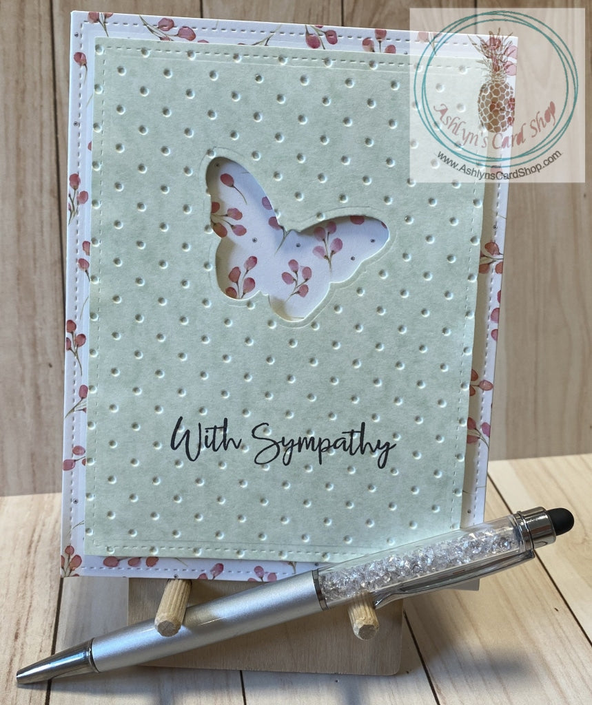 Butterfly Sympathy Card - A butterfly shape die cut out of a green patterned paper cardstock panel that has an embossed textured background and faux stitching detail.  The green panel is popped up on a patterned paper background that also has faux stitching detail.  External sentiment reads "with sympathy" and the internal sentiment reads "I am here for you always." Card size is 4.25 x 5.5" (A2). Coordinating envelope included (A2). Pink floral option.