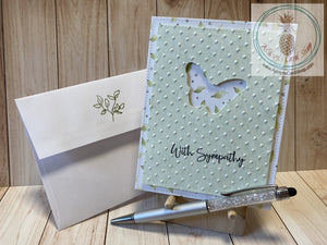 Butterfly Sympathy Card - A butterfly shape die cut out of a green patterned paper cardstock panel that has an embossed textured background and faux stitching detail.  The green panel is popped up on a patterned paper background that also has faux stitching detail.  External sentiment reads "with sympathy" and the internal sentiment reads "I am here for you always." Card size is 4.25 x 5.5" (A2). Coordinating envelope (shown) included (A2). Green leaf option.