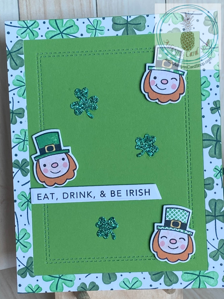 A handmade, high-quality St. Patrick’s Day card.  Who doesn’t want to eat, drink and be Irish? Make someone smile by sending them a cheery bright green card with shamrocks and leprechauns! An ink blended shamrock border and faux stitching detail on the green card panel accent the sentiment strip.  Card size: 4.25 x 5.5” (A2)  Coordinating white envelope included.