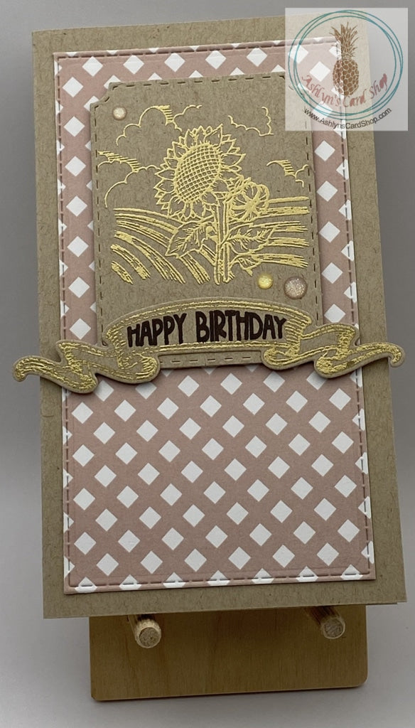 A happy birthday card with a sunflower scene embossed in gold. Two versions: check pattern background shown. Slimline card: 3.5 x 6.5". Coordinating envelope included.