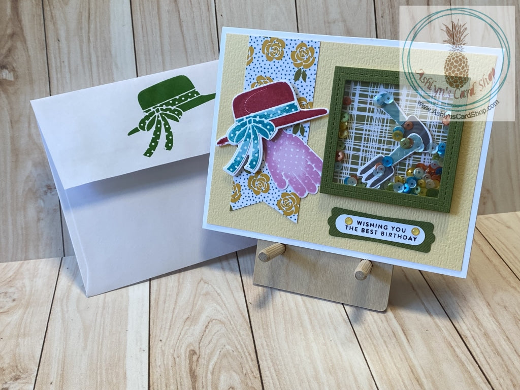 A fun gardening themed shaker card for the lady gardener in your life. Gardening tools and multiple colours of sequins are ready to be shaken around on the front of a pretty yellow card adorned with a sun hat and a gardening glove resting on a banner of yellow roses and blue polka dots. The external sentiment reads "wishing you the best birthday" and the internal sentiment reads "to my sweet, kind and beautiful friend." A2 card size (4.25 x 5.5"). Coordinating envelope (shown) included.