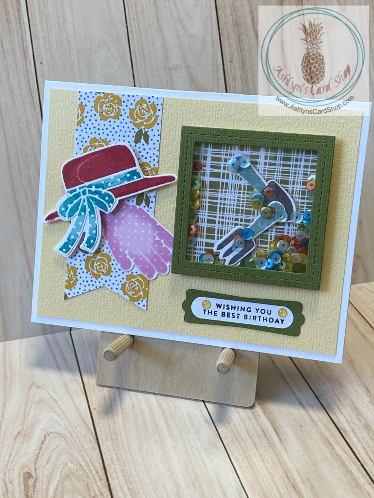 A fun gardening themed shaker card for the lady gardener in your life. Gardening tools and multiple colours of sequins are ready to be shaken around on the front of a pretty yellow card adorned with a sun hat and a gardening glove resting on a banner of yellow roses and blue polka dots. The external sentiment reads "wishing you the best birthday" and the internal sentiment reads "to my sweet, kind and beautiful friend." A2 card size (4.25 x 5.5"). Coordinating envelope included.