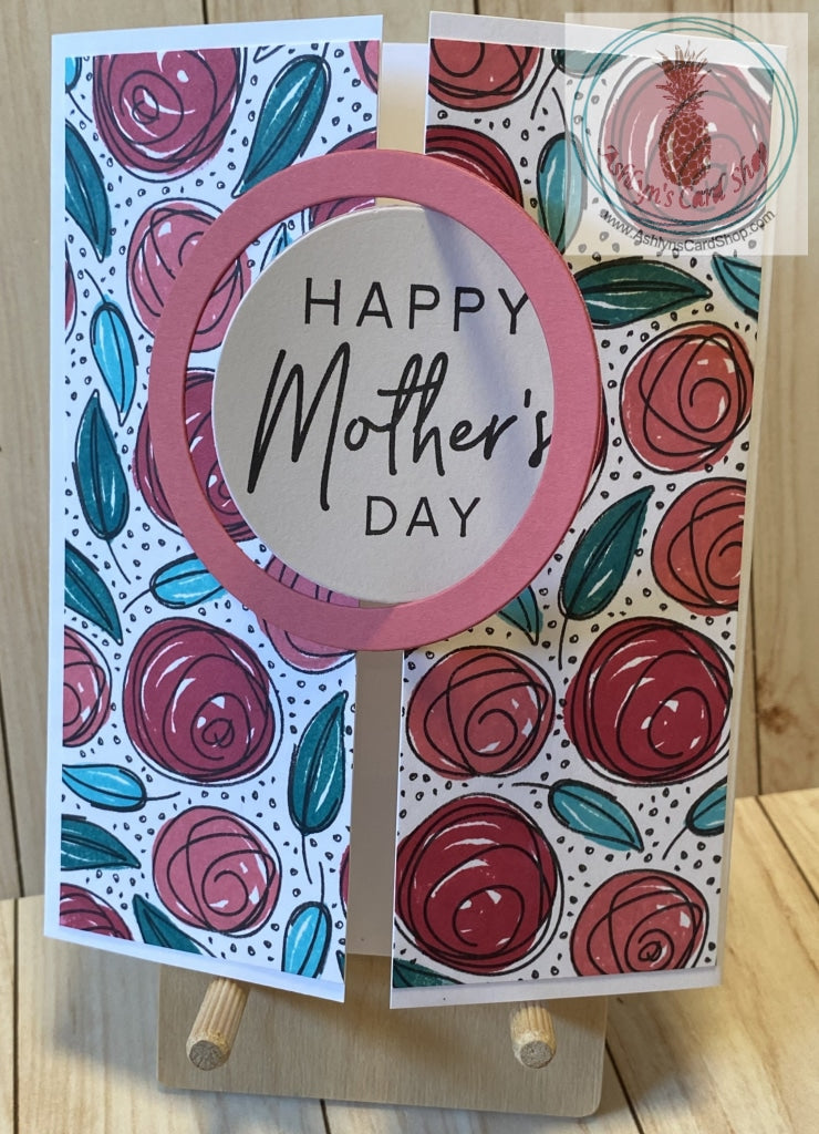 A gatefold Mother's Day card with an interlocking circle and frame on the front. The hand stamped background pattern consists of whimsical roses stamped in red and pink and greenery stamped in two shades of teal. External sentiment reads "Happy Mother's Day" and the internal sentiment reads "Words cannot begin to explain how much your love and support has meant to me." Card size is A2 (4.25 x 5.5"). Coordinating envelope included.