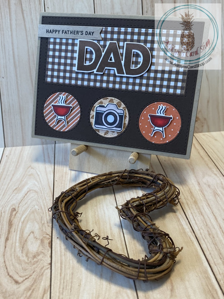 Father's Day card with a barbeque theme. High quality handmade greeting card with hand coloured images that represent Dads. Mounted to a kraft coloured card base, a dark brown die cut frame with inlaid pieces of patterned paper showcases the sentiments and coloured images in this design. Patterned paper varies amongst the versions. A2 Card Size: 4.25 x 5.5". Coordinating envelope included. Grill & Camera version.