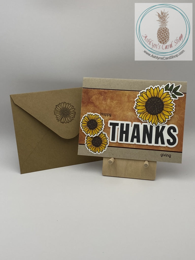 Thanksgiving card with sunflowers as accents. Hand coloured flowers on a patterned paper background. Two backgrounds available: orange version. A2 size card: 4.25 x 5.5". Coordinating envelope (shown) included.