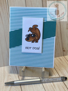 A cool sunglass-wearing dog dude doing a handstand is handcoloured on a white stitched rectangle die cut which is popped up over a diagonal card stock strip that coordinates with the striped coloured patterned paper background. Attached to a white card base. External sentiment reads "hot dog!"; internal sentiment reads "and the award for best parent goes to . . . you. Thanks, Dad". A2 card size: 4.25 x 5.5".  Coordinating envelope included. Teal version.