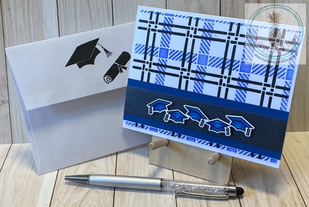 Hand coloured graduation caps popped up on a black shimmer strip of paper and again on blue cardstock. The strip was attached to a blended plaid background of blue and black. Inside sentiment reads "the tassel was worth the hassle". A2 card size: 4.25 x 5.5".  Coordinating envelope (shown) included.
