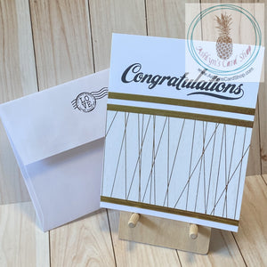 High quality handmade wedding cards featuring simple gold and white designs with  sentiments stamped in black. Decorative tape and foil tape in gold mounted on a white card base.  Sentiments read "Congratulations on your wedding". A2 card size: 4.25 x 5.5".  Coordinating envelope included (shown). Triple stripe version.
