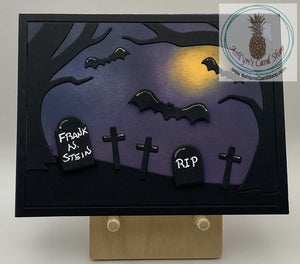 Silhouette scene of bats flying over a treed cemetery at night. Headstones read RIP and Frank N. Stein. A2 size card (4.25 x 5.5"). Coordinating envelope included.