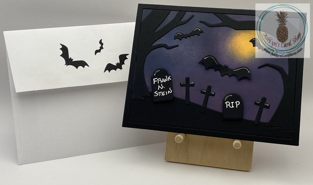 Silhouette scene of bats flying over a treed cemetery at night. Headstones read RIP and Frank N. Stein. A2 size card (4.25 x 5.5"). Coordinating envelope (shown) included.