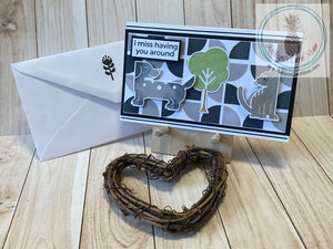 Graphic stenciled backgrounds with a variety of stylized animal shapes and sentiments to choose from. Mini slim card size (3.5 x 6").  Coordinating envelope (shown) included. Dog & Cat I Miss Having You Around card.