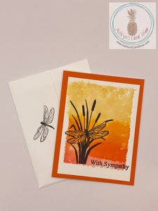 Sympathy card with a watercolour wash background stamped with a dragonfly (on orange) in silhouette. The sentiments read: with sympathy (external) and may your heart find comfort (internal). A2 sized card: 4.25 x 5.5". Coordinating envelope included (shown).