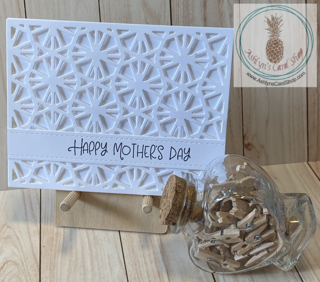 Whimsical hexagon background in a white on white design is popped up on a white card base. The sentiment strip reads "Happy Mother's Day" and the internal sentiment reads "we love you! For all you do and all you are".  Card size A2 (4.25 x 5.5") Coordinating envelope included
